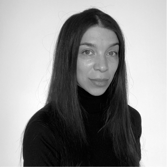 Anja Tyson, A black and white image of a woman with long dark hair, wearing a black turtleneck.