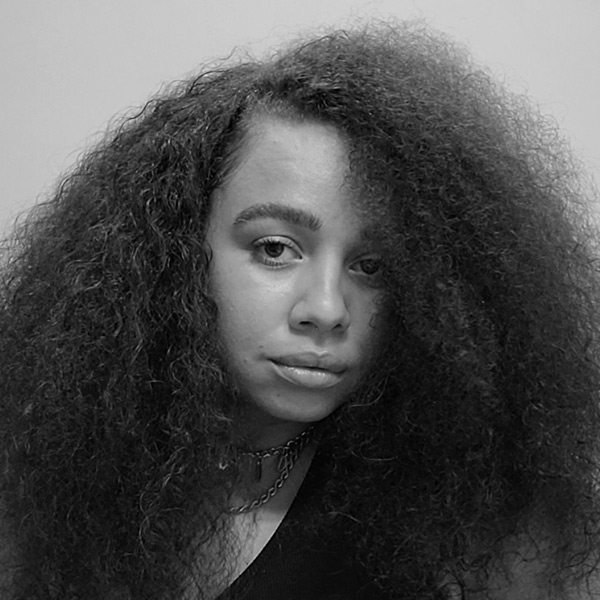 Paloma Rae, A black and white image of a mixed-race woman with dark curly hair.