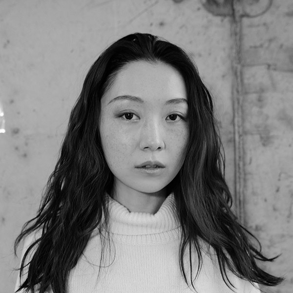 Xin Liu, A black and white image of a young Chinese-American with long slightly wavy brown hair, wearing a white sweater